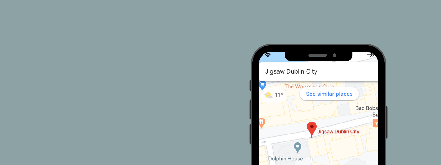Grey background with an iphone that's searching Jigsaw Dublin City on maps