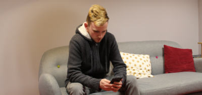 What- is-Cyberbullying? young man on a sofa on his phone