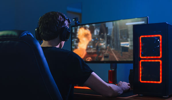 young man playing online immersive gamer, view over his shoulder
