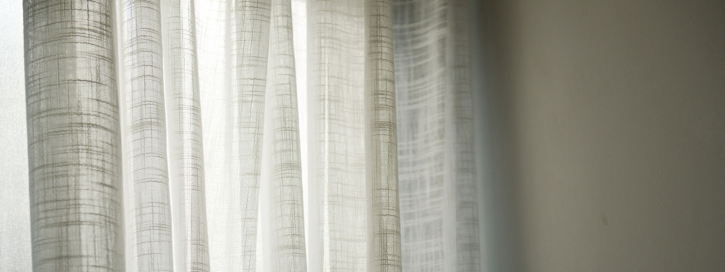 picture of curtains fully drawn with some sun coming through