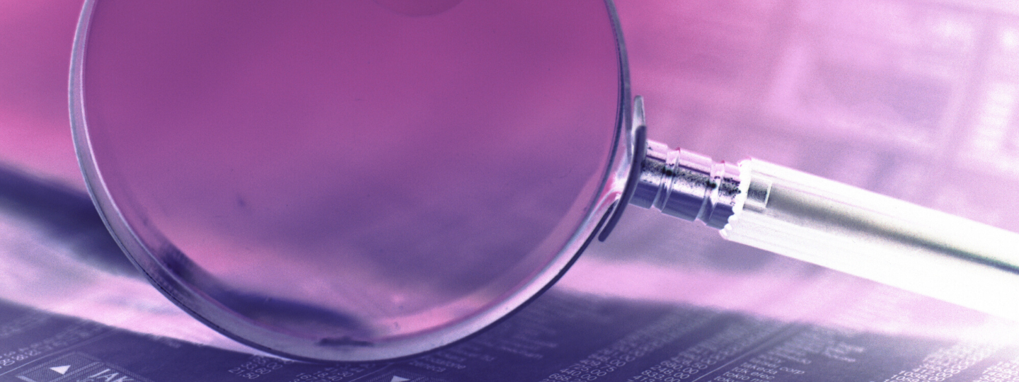 Magnified glass on a pink background