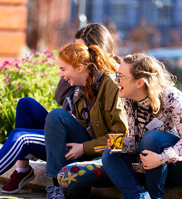 young people laughing sitting on the ground