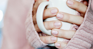 Managing-feelings Person in pink jumper holding a white cup