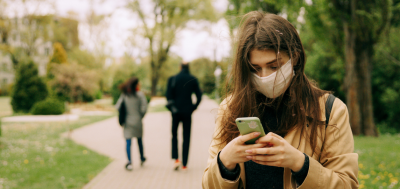 Information image of girl on her phone wearing a face mask