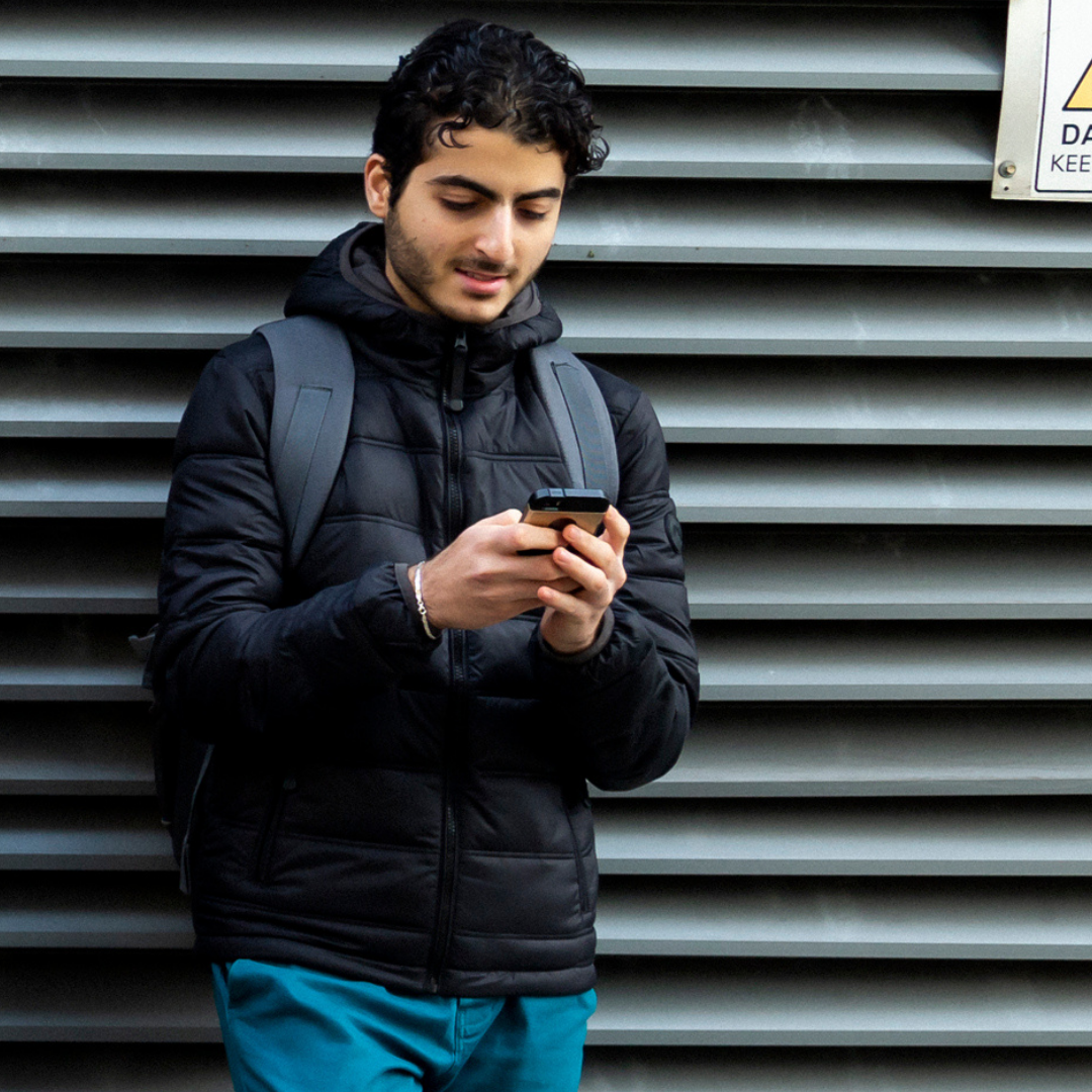 Young man holding phone texting