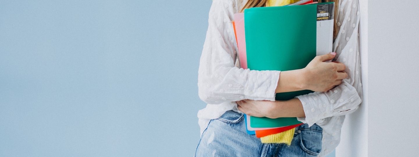 a girl holding colourful folders