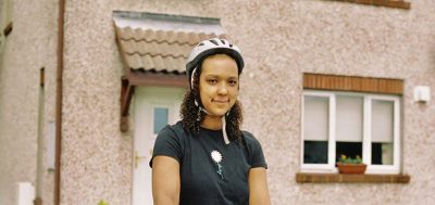 Information Amina, one of our volunteers in front of her house with cycling helmett
