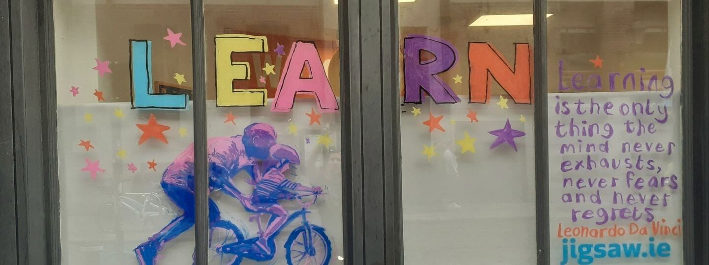 Banner for September's Rolling Gallery for 'Learn' with adult and boy on a bike
