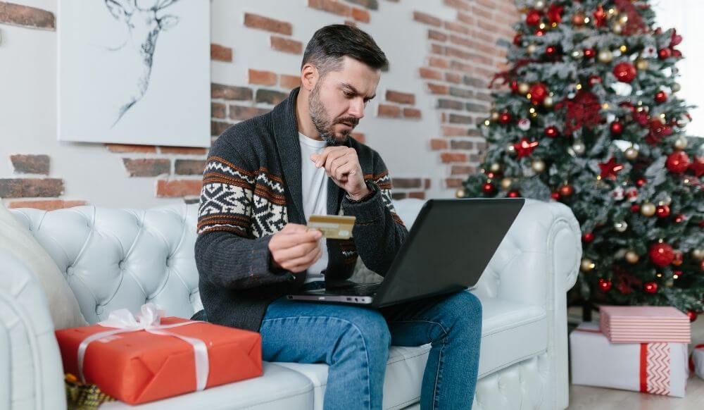 Money worries man-with-beard-sitting-couch-during-new-year-holidays-nervous-worried-trying-get-loan-online-using-laptop-credit-card