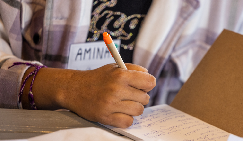close up of young person writing in notebook