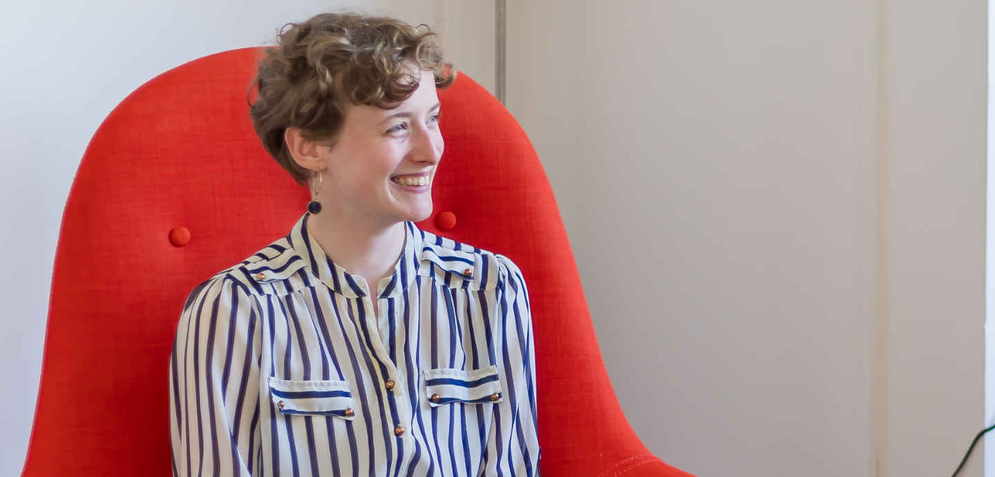 young person sitting down in red chair