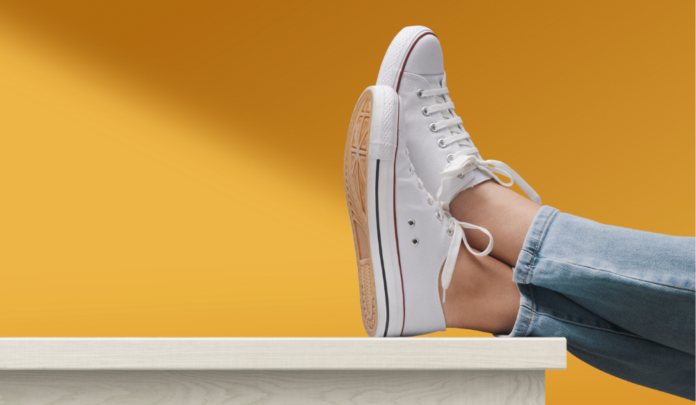 feet up on a white table with a yellow background